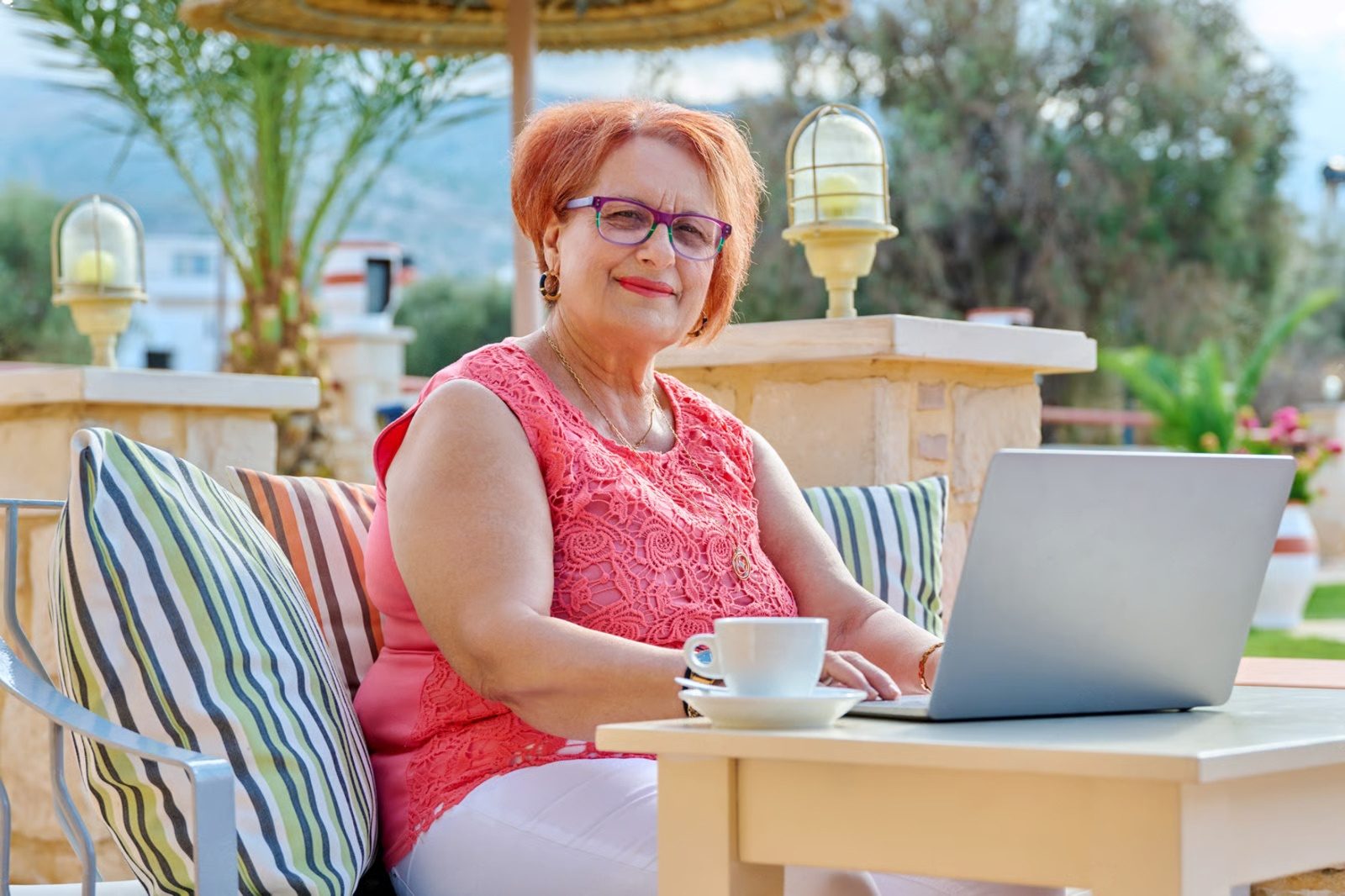 Una señora trabaja con su computadora portátil en una terraza